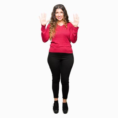 Gösterilen ve parmakları ile işaret kırmızı kazak giyen genç güzel kadın kendinden emin ve mutlu gülümseyerek süre on numara.