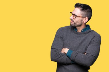 İkna ve kendine güvenen tarafına silahlarla seyir gülümseyen izole arka plan üzerinde gözlük takan genç yakışıklı adam geçti