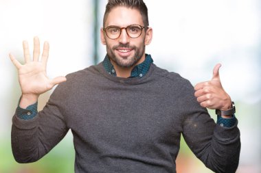 Gösterilen arka plan üzerinde gözlük takan genç yakışıklı adam izole ve parmakları ile işaret kendinden emin ve mutlu gülümseyerek süre 6 numara.