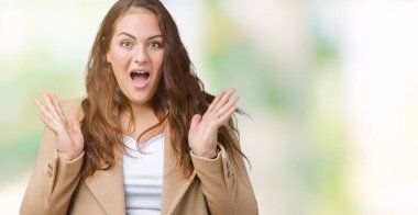 Artı boyutu genç kadın güzel üzerinde kış ceket giymiş deli kutluyor arka plan izole ve silah ile başarı için yükseltilmiş ve açık gözleri heyecanlı çığlık hayrete düşürdü. Kazanan kavramı