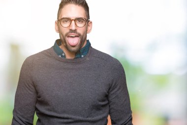 Genç yakışıklı adam gözlük dilini izole arka plan üzerinde mutlu komik ifade ile dışarı. Duygu kavramı.