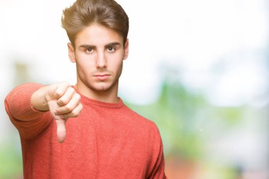 Yakışıklı delikanlı mutsuz ve kızgın ret gösterilen ve başparmak aşağı hareketi ile negatif seyir izole arka plan üzerinde. Kötü ifade.