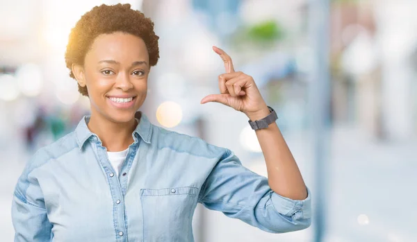孤立した背景の笑顔と自信を持ってカメラを見ながら指でサイズ記号をやって手でジェスチャーを若い美しいアフリカ系アメリカ人女性 測定概念 — ストック写真