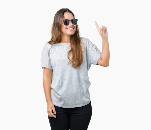 年轻美丽的黑发女人戴着太阳镜在孤立的背景指向手指与成功的想法 退出和快乐 — 图库照片