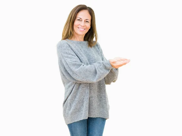 美丽的中年妇女穿着冬季毛衣在孤立的背景指向身边的手和开放的手掌 呈现广告微笑的快乐和自信 — 图库照片