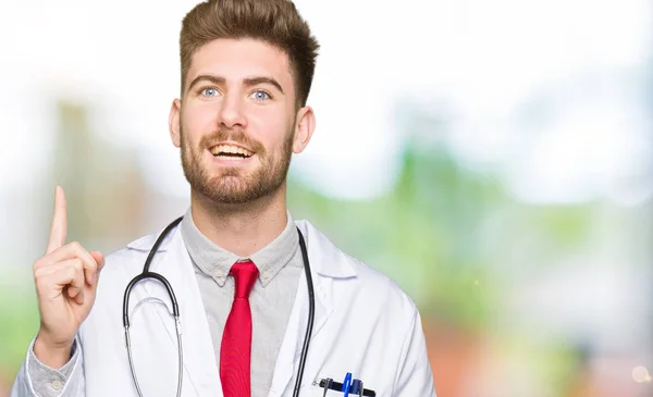 Νέος Ωραίος Γιατρός Άνθρωπος Φορώντας Ιατρική Παλτό Δείχνει Δάχτυλο Επιτυχημένη — Φωτογραφία Αρχείου