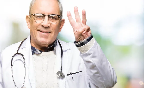 英俊的高级医生男子穿着医疗外套显示和指着手指三号 同时微笑自信和快乐 — 图库照片