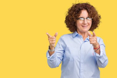 Gözlük kamera ile mutlu ve komik yüz için parmakları işaret izole arka plan üzerinde giyen güzel orta ager üst düzey businees kadın. İyi enerji ve vibes.