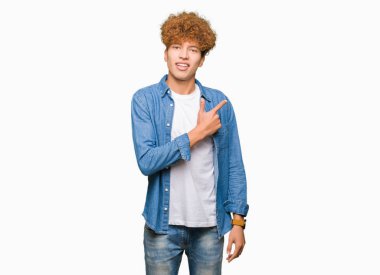 Denim ceket neşeli bir gülümseme ile el ve parmak kadar yan yüzünde mutlu ve doğal ifade ile işaret yüz afro saçlı Genç yakışıklı adam