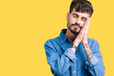 Yakışıklı delikanlı uyku yorgun hayal ve ellerle birlikte poz ile kapalı gözler gülümseyen izole arka plan üzerinde.