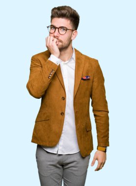 Stresli ve gergin elle çivi ısırma ağzına bakarak gözlüklü genç yakışıklı iş adamı. Anksiyete sorunu.