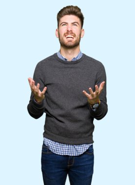 Genç yakışıklı zarif adam çılgın ve kızgın bağırarak ve agresif ifade ve silah kaldırdı bağırıyordu. Hayal kırıklığı kavramı.