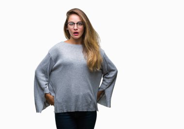 Korkuyor ve şok sürpriz ifade, korku ve heyecan yüz ile izole arka plan üzerinde gözlük takan genç güzel sarışın kadın.