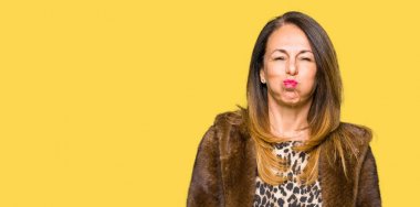 Güzel Orta Çağ şık kadın vizon ceket komik yüzü ile yanaklarını giyiyor. Ağız hava ile şişirilmiş, çılgın ifade.