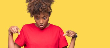 Güzel genç Afro-Amerikan kadın yüzünden izole arka plan işaretleme aşağı reklam, sürpriz yüz ve açık ağız gösterilen parmakları ile