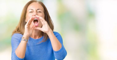 Orta yaş kızgındım yüksek sesle bağırarak izole arka plan üzerinde kış kazak giyen güzel kadın ağzına eller