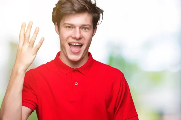 年轻的帅哥穿着红色的 T恤在孤立的背景显示和手指第四 同时微笑着自信和快乐 — 图库照片