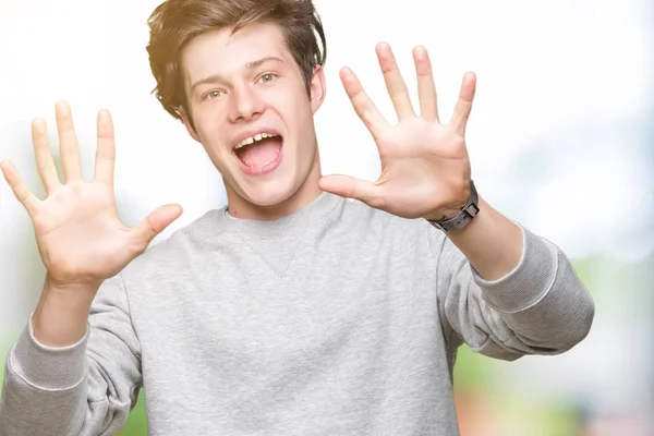 Knappe Sportieve Jongeman Dragen Sweatshirt Geïsoleerd Achtergrond Weergegeven Met Vingers — Stockfoto