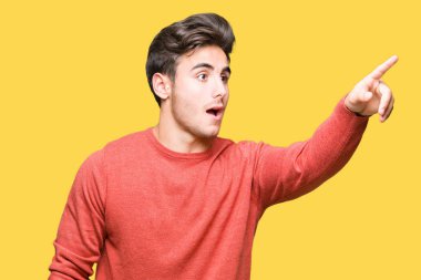 İzole arka plan ile sürpriz devam et, parmakla üzerinden yakışıklı delikanlı ağız açık ifade, önünde bir şey hayret