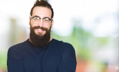 Uzun saç ve sakal giyen genç hipster adamla gülen alma veya jest vererek birlikte el avuç içi ile gözlük. Ayrı tutma ve koruma