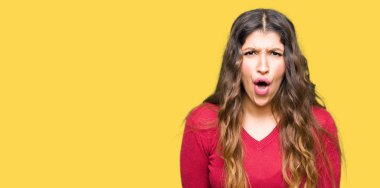 Kırmızı kazaklı korkuyor ve şok sürpriz ifade, korku ve heyecan yüz ile giyen genç güzel kadın.