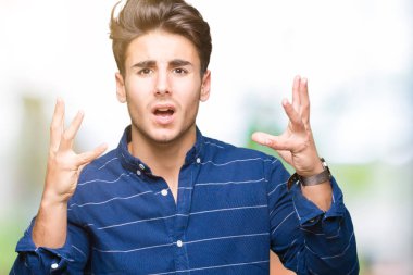 Üzerinde Donanma gömlek giymiş genç yakışıklı adam arka plan deli izole ve deli bağırarak ve agresif ifade ve silah kaldırdı bağırıyor. Hayal kırıklığı kavramı.