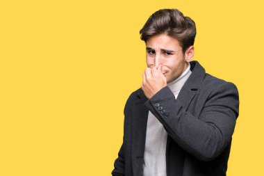 İzole arka plan kokulu üzerinde kış ceket pis ve iğrenç bir şey, dayanılmaz koku, holding nefes parmak ile burun üzerinde giyen genç zarif adam. Kötü kokuyor kavramı.