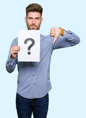 Kızgın yüz, eksi işareti aşağı antipati başparmak ile gösterilen, ret kavramı ile soru işareti ile kağıt tutan genç yakışıklı adam