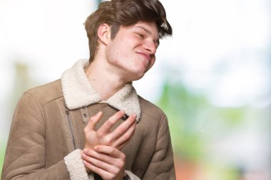 Elleri ve parmakları, artrit inflamasyon izole arka plan acı acı üzerinde kış ceket giyen genç yakışıklı adam