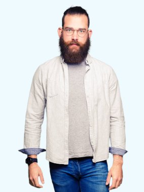 Gevşek ciddi ifade ile yüzünde gözlüklü genç sarışın adam. Basit ve doğal kameraya bakıyor.