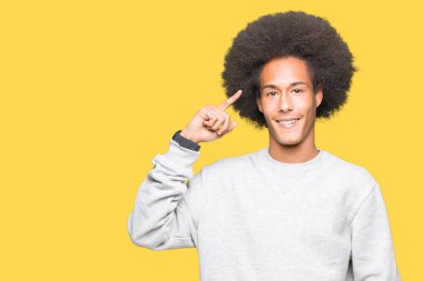 Sportif kazak gülen işaret giyen afro saçlı genç Afro-Amerikan adam başına bir parmak, harika bir fikir ya da düşünce, iyi hafıza ile