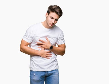Yakışıklı delikanlı üzerinde beyaz t-shirt giyen izole mide üzerinde el ile arka plan çünkü mide bulantısı, ağrılı hastalık hasta hissediyor. Ağrısı kavramı.