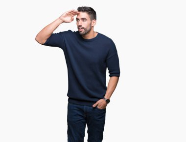 Üzerinde kazak giyen genç yakışıklı adam arka plan çok mutlu ve gülümseyen uzakta el ile üzerine kafa seyir izole. Arama kavramı.