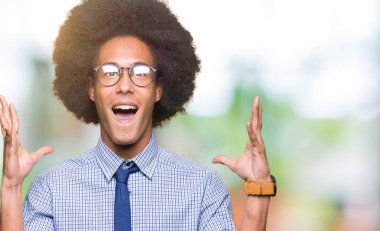 Deli kutluyor gözlük takan ve silah ile başarı için heyecanlı çığlık kaldırdı ve açık gözleri hayret afro saçlı genç Afro-Amerikalı iş adamı. Kazanan kavramı