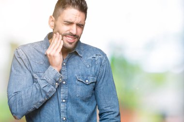 Yakışıklı delikanlı diş ağrısı veya dişlerde dişlerle ilgili hastalık nedeniyle ağız acı ifadesi ile el ile dokunmak izole arka plan üzerinde. Diş hekimi kavramı.