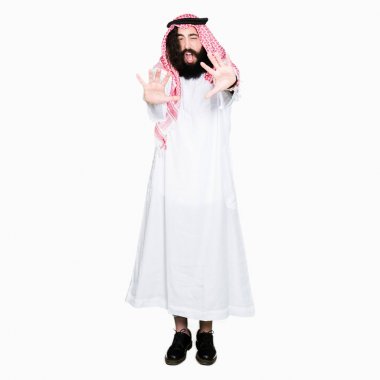 Şokta bağırarak Arap iş adamı geleneksel keffiyeh eşarp korkuyor ve dehşet korku ifade dur hareketi el ile ile uzun saçlı. Panik kavramı.