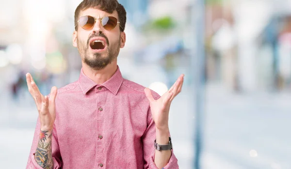 Homem Bonito Jovem Usando Óculos Sol Sobre Fundo Isolado Louco — Fotografia de Stock