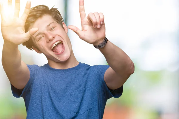 年轻的帅哥穿着蓝色的 T恤在孤立的背景显示和手指指向七 同时微笑着自信和快乐 — 图库照片
