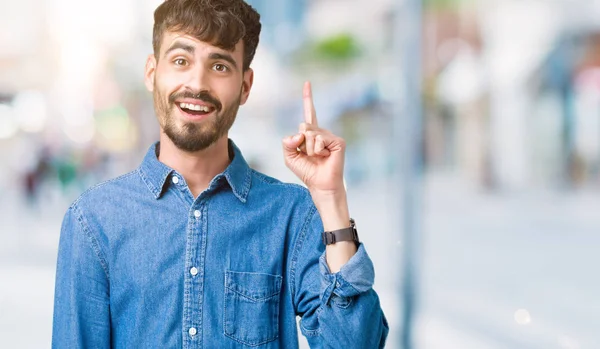 年轻英俊的男人在孤立的背景下 指着成功的想法 退出和快乐 第一个 — 图库照片