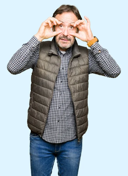 眠くなると朝の疲労のために疲れ 指で目を開こうとして冬のベストを着て中年ハンサムな男 — ストック写真