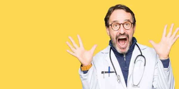 Bonito Médico Meia Idade Vestindo Casaco Médico Celebrando Louco Espantado — Fotografia de Stock