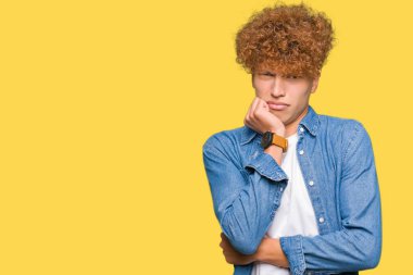 Afro saç ile genç yakışıklı adam denim ceket giymiş görünümlü vurguladı ve ağız ısırma çiviler eller ile gergin. Anksiyete sorunu.