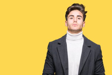 Üzerinde kış ceket giyen genç zarif adam arka plan gevşek yüzünde ciddi bir ifade ile izole. Basit ve doğal kameraya bakıyor.