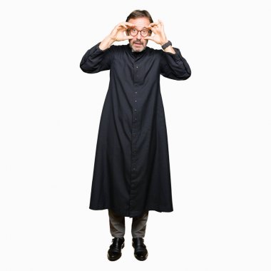 Katolik giyen orta yaş rahip adam robe parmaklarıyla, uykulu ve sabah yorgunluk için yorgun gözlerini açmaya çalışıyor