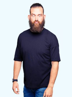 Genç Sarışın giyiyor rahat t-shirt yapma balık yüz dudaklı, çılgın ve komik bir jest adam. Komik ifade.