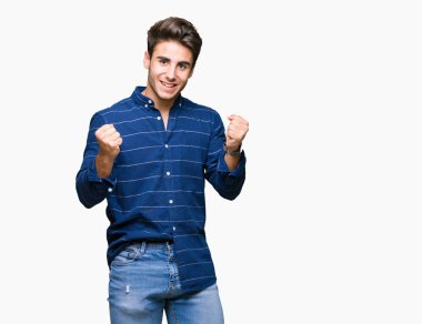 Yakışıklı delikanlı izole arka plan kutlama üzerinde Donanma gömlek giymiş şaşırttı ve başarı için kaldırdı kollarını açarak hayret ve gözleri açık. Kazanan kavramı.