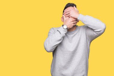 Yakışıklı delikanlı izole arka plan kaplaması gözler ve ağız el ile üzerinden sweatshirt giyen şaşırttı ve şok. Duygu gizleme