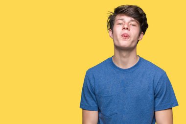 Genç yakışıklı adam giyiyor mavi t-shirt dilini izole arka plan üzerinde out komik ifade ile mutlu. Duygu kavramı.