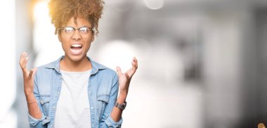 Güzel genç Afro-Amerikan kadın üzerinde gözlük takan arka plan deli izole ve deli bağırarak ve agresif ifade ve silah kaldırdı bağırıyor. Hayal kırıklığı kavramı.