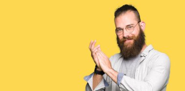 Genç sarışın adam gözlük giyen alkışlar ve mutlu ve neşeli alkışlar, gülümseyen gururlu eller birlikte